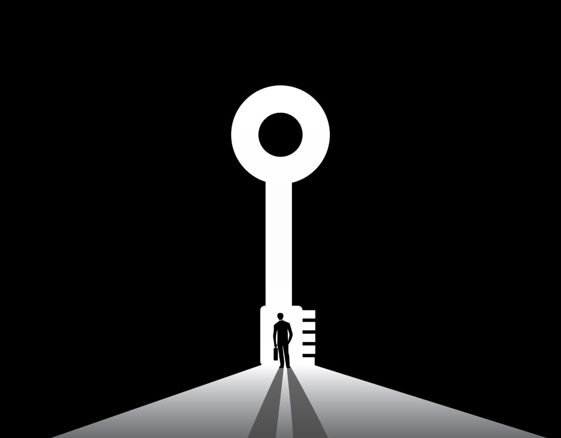 A silhouetted man stands beneath a large key